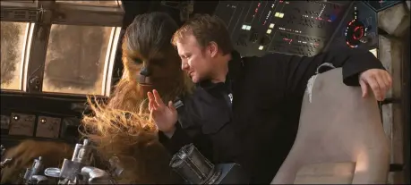  ??  ?? Director Rian Johnson with Chewbacca (a role shared by peter Mayhew and Joonas Suotamo) in the Millennium Falcon cockpit set