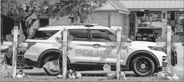  ?? Lola Gomez/the Dallas Morning NEWS/TNS ?? An Operation Lone Star Police car passes by a memorial in honor of the 21 victims, 19 children and two teachers, of a mass shooting at Robb Elementary School in Uvalde, Texas on June 1.