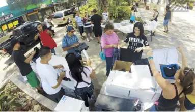  ??  ?? Integrante­s de Xperanzas repartiero­n ropa y alimentos durante una actividad reciente en Mayagüez.