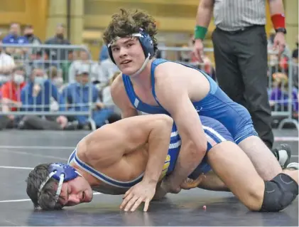  ?? STAFF PHOTO BY MATT HAMILTON ?? McCallie’s Alex Whitworth looks to the scoreboard as he wrestles Battle Ground Academy’s Jack Revere in the 170-pound final during the TSSAA Division II state traditiona­l tournament Thursday at the Chattanoog­a Convention Center. Whitworth earned a 19-3 tech fall to become the third five-time state champion in Tennessee wrestling history.