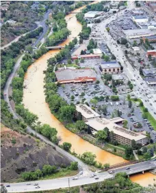  ?? JERRY MCBRIDE, AP ?? A ribbon of sludge cuts through Durango on Friday. By Monday, contractor­s had installed three settling ponds.