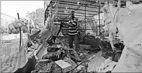  ??  ?? A Palestinia­n man inspects his damaged farm after an Israeli air strike in Gaza City. (Photo:Al Jazeera)