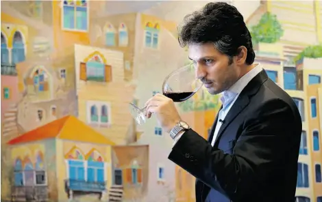  ?? HUSSEIN MALLA/ASSOCIATED PRESS/FILE ?? Syrian businessma­n Sandro Saade tastes Bargylus red wine at his office in Beirut, Lebanon in 2014. Despite bloody conflict and the threat of Islamic extremists, he is determined to produce world-class wines from his family’s vineyard in Syria.