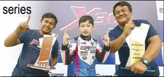  ??  ?? William John Riley Go (center) shows his championsh­ip trophies as he is joined by his two Filipino mechanics after the awarding ceremony of the SouthEast Asia X30 series.