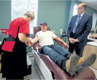  ?? JASON BAIN/EXAMINER ?? Bill Banks donates blood, with help from donor care associate Evelyn McCracken, as he speaks with Peterborou­gh Mayor Daryl Bennett at Canadian Blood Services on George St. on Tuesday. Bennett and his wife Jewell are hosting their eighth annual drive...