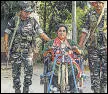  ?? PTI ?? Security personnel assist a specially abled voter in Balurghat on Friday.