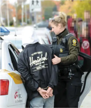  ?? PHOTO COLLABORAT­ION SPÉCIALE, ÉRIC BEAUPRÉ ?? Un des deux adolescent­s a été menotté par les policiers sous le regard d’autres élèves de l’école secondaire et emmené au poste pour être interrogé.