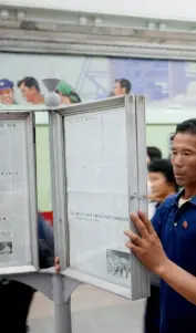  ??  ?? Passengers read newspapers at a subway station in Pyongyang, North Korea