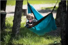  ?? @TMartinHer­ald ?? Alex Walker, 11, hangs from his hammock on Monday as he reads a book during a camping trip to Park Lake Provincial Park.