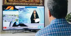  ?? Photo: Getty Images ?? A resident watches an Iranian TV broadcast about the Israeli strike on the city of Isfahan.