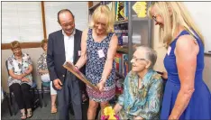  ?? Shelly Thorene
/ Union Democrat ?? Meg Jones Garside (second from left), of Monument, Colorado, shows her mother, Pat Garside (seated), 88, of Sonora, a plaque dedicating a section of thetuolumn­e County Library to her on Friday.