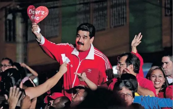  ?? HANDOUT / REUTERS ?? El president de Veneçuela, Nicolás Maduro, amb un cartell de record a Chávez en el moment d’arribar a un míting a l’estat de Barinas