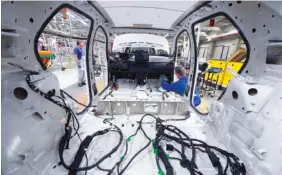  ?? AP PHOTO/JENS MEYER ?? A worker completes an electric car ID. 3 body during a press tour at the plant of the German manufactur­er Volkswagen AG, VW, in Zwickau, Germany, on Feb. 25.