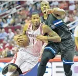  ?? ERIC CHRISTIAN SMITH/ASSOCIATED PRESS ?? Rockets F Trevor Ariza, left, drives past Magic F Serge Ibaka toward the basket on Tuesday. Ibaka had a game-high 28 points, while Ariza scored 20.