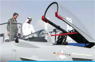  ??  ?? DUBAI: Crown Prince of Dubai, Sheikh Hamdan bin Mohammed bin Rashid Al-Maktoum (right), looks at an Eurofighte­r Typhoon fighter jet during the Dubai Airshow yesterday in the United Arab Emirates. —AFP