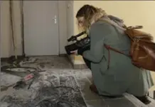  ?? CLAUDE PARIS, THE ASSOCIATED PRESS ?? A video-journalist films the wreckage of an entrance of an apartment building after a raid of a French anti-terrorist police unit in Clapiers, southern France, Friday.