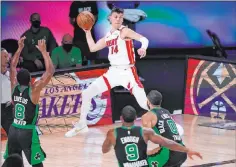  ?? Mark J. Terrill The Associated Press ?? Heat guard Tyler Herro leaps to make a pass over Boston’s Kemba Walker (8), Brad Wanamaker
(9) and Jayson Tatum (0) in Thursday’s Game 2 of the Eastern Conference finals. Miami trailed by as many as 17, but came back to win and are up 2-0 in the series.