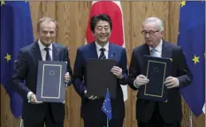  ??  ?? Japanese Prime Minister Shinzo Abe (center) European Union’s Council President Donald Tusk (left) and European Union’s Commission President Jean-Claude Junker pose after signing a contract, on Tuesday, at the prime minister’s office in Tokyo. MARTIN BUREAU/POOL PHOTO VIA AP