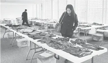  ??  ?? People look at the clothes of victims killed by the army during the 1980-2000 civil war in Peru, whose bodies were exhumed from a mass grave in Peru’s Andean region of Ayacucho, during an exhibition at the Public Ministry in Lima. The one-week...