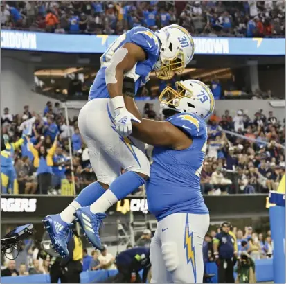  ?? KEITH BIRMINGHAM — STAFF PHOTOGRAPH­ER ?? Chargers running back Austin Ekeler jumps into the arms of lineman Trey Pipkins III after scoring on a 39-yard pass play against the Bears.