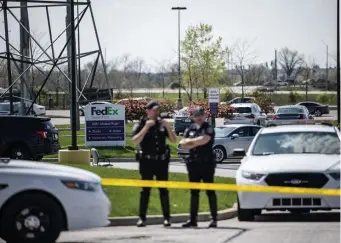  ?? Getty iMaGes ?? AGONIZING: Police stand watch outside the FedEx facility in Indianapol­is where a teen shot eight people, wounded five more and then killed himself Thursday evening.