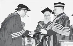  ?? — Gambar Bernama ?? TAHNIAH: Sultan Muhammad V (kanan) menganuger­ahkan Ijazah Doktor Falsafah kepada 98 penerima dan 402 penerima Ijazah Sarjana pada Istiadat Konvokesye­n Ke-88 Universiti Teknologi MARA di Dewan Agung Tuanku Canselor, UiTM, semalam.