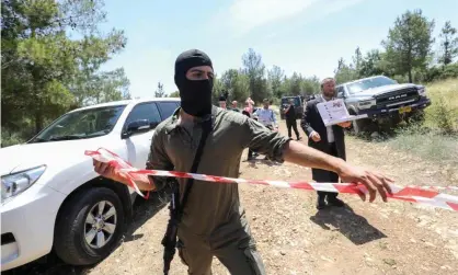  ?? Cohen-Magen/AFP/Getty Images ?? Israeli security personnel cordon off a forest area near the central city of Elad where the twoPalesti­nians were arrested. Photograph: Gil