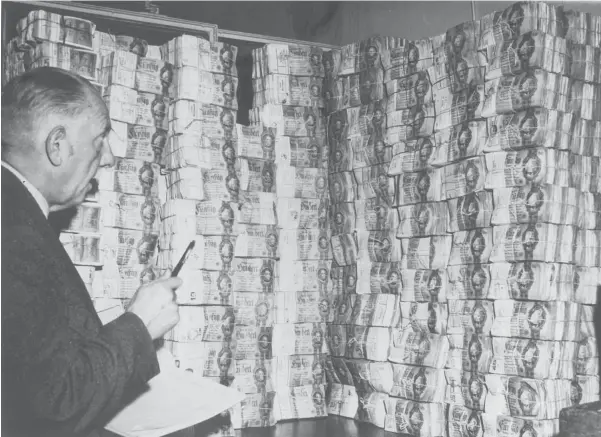  ?? Foto: akg-images ?? Im Juni 1948 wurde in den Westsektor­en die D-Mark eingeführt: Ein Angestellt­er der Hamburger Sparkasse steht vor einem Stapel gebündelte­r Reichsmark­scheine.