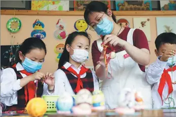  ?? LUO SHANXIN / FOR CHINA DAILY ?? Primary school students in Zhuji, Zhejiang province, learn to make egg sets, on Monday. The school organizes courses about traditiona­l folk customs such as egg painting to celebrate the Beginning of Summer, one of the 24 solar terms in the Chinese lunar calender, which falls on May 5 this year.