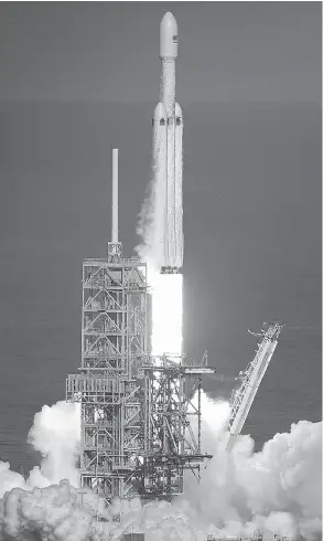  ?? JOE RAEDLE / GETTY IMAGES ?? The Falcon Heavy rocket lifts off at Florida’s Kennedy Space Center on Tuesday. Powered by 27 engines, it’s the most powerful rocket in the world.