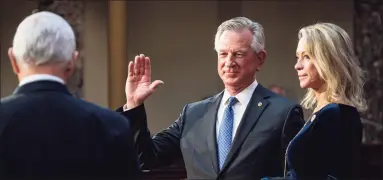  ?? Pete Marovich / Associated Press ?? Sen. Tommy Tuberville, R-Ala., the former Auburn football coach, is joined by his wife, Suzanne, as he takes the oath of office from Vice President Mike Pence during a re-enactment ceremony Jan. 3 in the Capitol. Three days later, the building would be invaded by rioters, some of them chanting that the vice president should be hung.