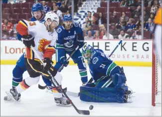  ?? The Canadian Press ?? Vancouver Canucks goaltender Anders Nilsson kicked out his pad to stop this scoring chance by Calgary Flames forward Sam Bennett as Vancouver defencemen Andrey Pedan and Chris Tanev look on during...