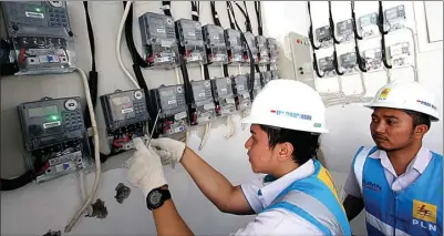  ?? MIFTAHULHA­YAT/JAWA POS ?? CERMAT: Petugas PLN Area Bulungan Distribusi Jakarta Raya menyambung tambahan daya pelanggan 1.300 VA menjadi 2.200 VA di kawasan Kebayoran Lama, Jakarta, kemarin (20/6). Menyambut Lebaran, PLN memberikan promo diskon biaya penambahan daya.