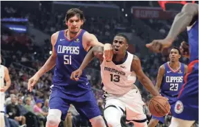  ??  ?? Jaren Jackson Jr. (13) of the Grizzlies is defended by Boban Marjanovic (51) of the Clippers on Friday in Los Angeles. MARCIO JOSE SANCHEZ/AP