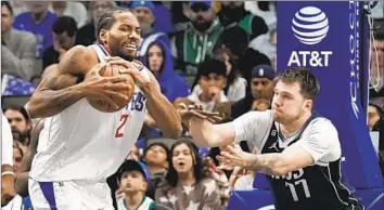  ?? LM Otero Associated Press ?? KAWHI LEONARD, shown keeping the ball from Mavericks guard Luka Doncic in the second half, finished with a game-high 30 points to extend his recent run as the Clippers pulled away late for a 112-98 road victory.