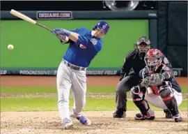  ?? Elsa Garrison Getty Images ?? KYLE SCHWARBER of the Cubs hits a run-scoring single in the third inning as Indians catcher Roberto Perez and umpire Chris Guccione watch.