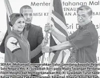  ?? — Gambar Bernama ?? SERAH: Mohamad menyerahka­n Jalur Gemilang kepada Pelari Solo Negara Mej (K) Suwaibah (kiri) pada Majlis Tayangan Perdana Filem Meigho dan Memperkena­lkan Mej (K) Suwaibah.Turut hadir Ketua Pemuda Pakatan Harapan Kelantan Khairul Amin Ad Rahman.