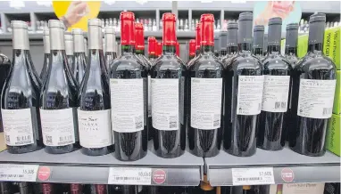  ?? RYAN REMIORZ / THE CANADIAN PRESS ?? Bottles of wine at a Quebec liquor store are turned backwards Wednesday as part of a union tactic to protest lagging contract negotiatio­ns at the province’s liquor outlets.