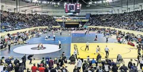  ?? [CHRIS LANDSBERGE­R/ THE OKLAHOMAN] ?? Wrestlers take to the mats for their matches during the Oklahoma high school state wrestling championsh­ips at Oklahoma City's Jim Norick Arena in February 2019.