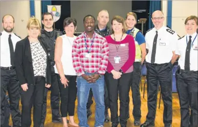  ??  ?? Glenda Crittenden, whose son was stabbed to death, fourth from left, next to Francis OseiAppiah, a former gang member, with police and staff at St Augustine Academy