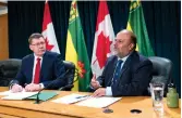  ??  ?? Saqib Shahab, chief medical health officer, right, speaks while Scott Moe, premier of Saskatchew­an, looks on at a COVID-19 news update at the Legislativ­e Building in Regina. (THE CANADIAN PRESS/Michael Bell)