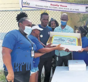  ?? (Photos: Anthony Lewis) ?? Chair of the fun day activities Oraldo Anderson (centre) and other volunteers present a