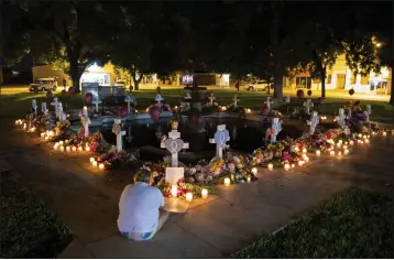  ?? PHOTOS BY IVAN PIERRE AGUIRRE — THE NEW YORK TIMES ?? A woman mourns Friday morning before the 21crosses bearing the names of the victims of the mass shooting at Robb Elementary School at a memorial set up in the town square in Uvalde, Texas.