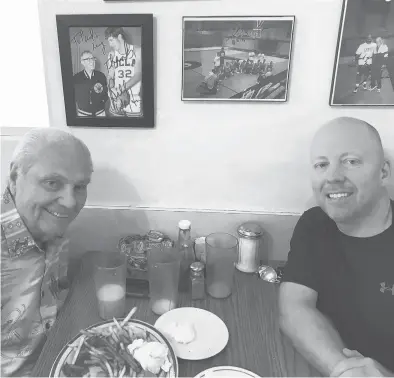  ?? UCLA ?? Hep Cronin, left, sits with his son and UCLA coach Mick Cronin in the booth where legendary coach John Wooden used to have breakfast.