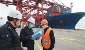  ?? YAO FENG / FOR CHINA DAILY ?? Customs officials verify documentat­ion of a container ship in Ningbo, Zhejiang province.