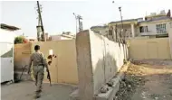  ?? – Reuters ?? CLOSE SCRUTINY: A security guard walks outside the Al Jazeera building in Baghdad, yesterday.