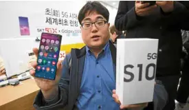  ?? —AFP ?? WHOWAS FIRST? A Korean consumer shows off the 5G Samsung smartphone he bought during a launch event in Seoul on April 5.
