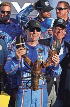  ?? BRIAN FLUHARTY, USA TODAY SPORTS ?? Kevin Harvick celebrates with a lobster after winning the Bad Boy Off Road 300 to advance in the Chase for the Sprint Cup.
