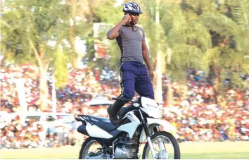  ??  ?? A policeman talking on his cellphone while riding a motorbike during displays at the Harare Agricultur­al show yesterday.