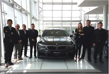  ??  ?? Tay (third right) together with Regas Premium Auto dealer principal Gavin Tay (second right) and their sales team pose with BMW 630i GT at the showroom.
